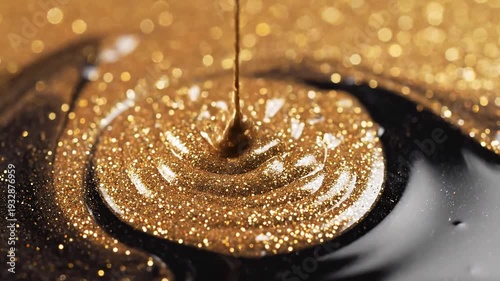 Closeup macro shot of thick viscous golden liquid with shimmering glitter particles pouring and swirling into a dark reflective surface creating mesmerizing patterns and textures.