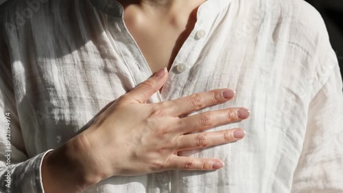 Hand on chest. A human hand rests gently on the chest as the body rises and falls subtly, showing calm and steady breathing.