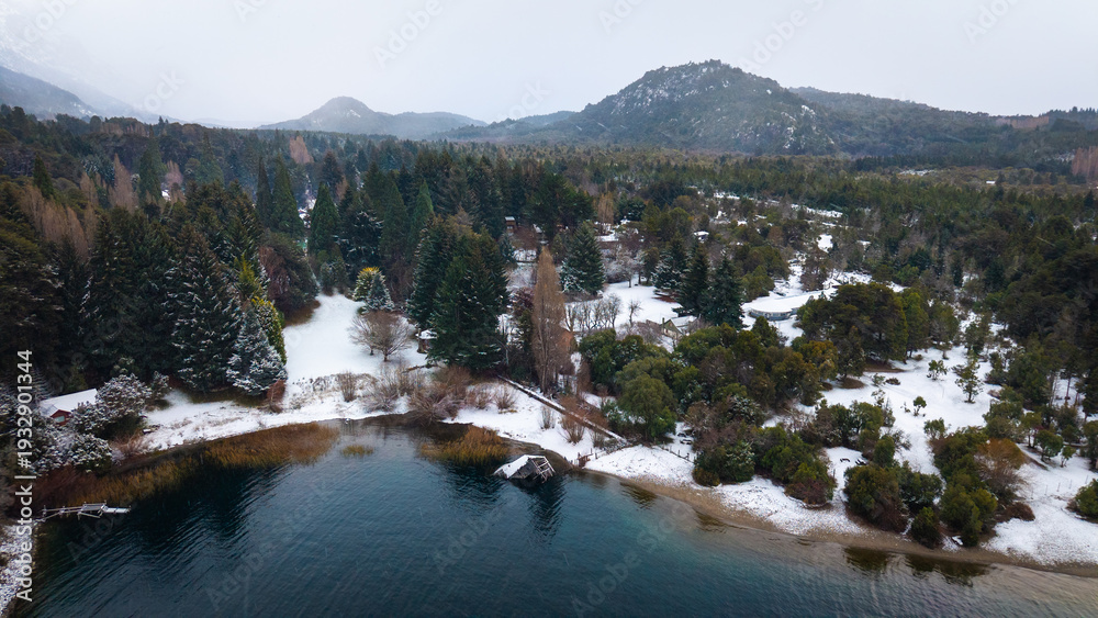Fototapeta premium Aerial view of snowy shoreline and forest in Colonia Suiza, Bariloche, Patagonia, Argentina during winter.