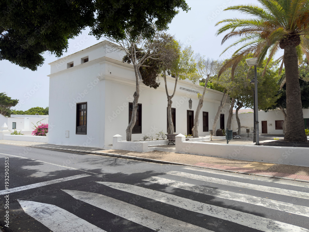 Fototapeta premium White building with palm trees and crosswalk.. Yaiza, Lanzarote, Spain