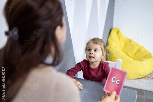 Bilde på lerret Speech therapist working with a young child using a c letter flashcard, assistin