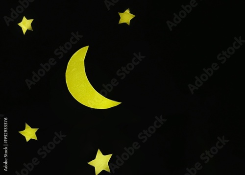 Paper crescent moon and stars on black background