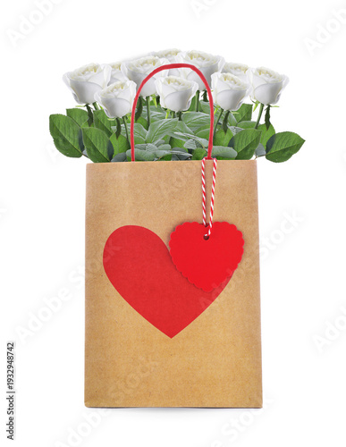 Roses in paper bag with red heart on white background. Romantic gift