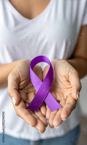 Purple ribbon held in hands symbolizing the elimination of violence against women