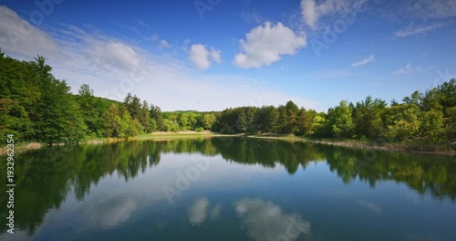 Reflections of trees in the Water Under Blue Sky And Fluffy White Clouds on a nice sunny day, panoramic nature  landscape Karandila mountain, Sliven, Bulgaria