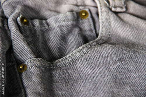 Bild auf Leinwand Close-up detail of a gray denim jeans front pocket with metal rivets and stitchi
