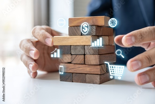 A person is building a precarious tower with wooden blocks with business and finance icons hovering around it