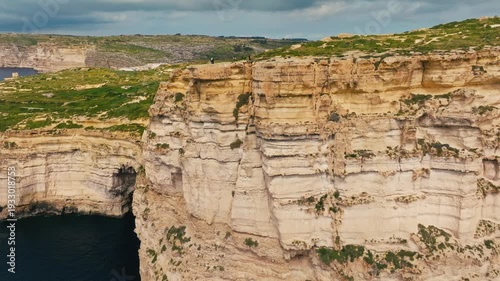 Drone view of Sanap Cliffs on Gozo island, part of Malta island. Green fields, rocks and cliffs, sea