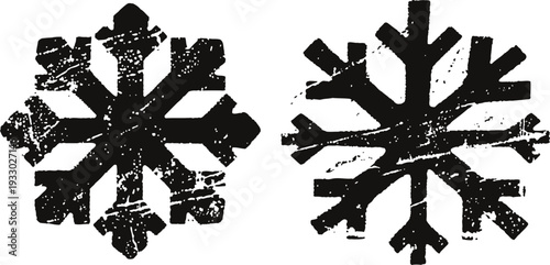 two black distressed snowflake icons with rough textured design isolated on white background