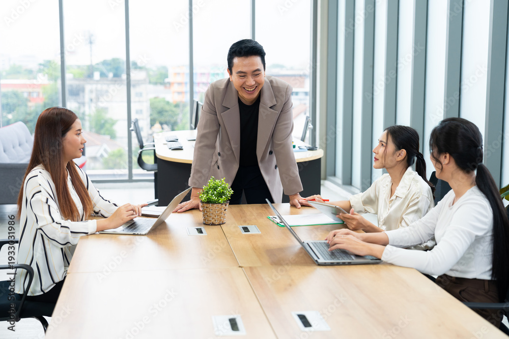 Fototapeta premium A group of professionals engage in a collaborative meeting in a modern office. The scene highlights teamwork, leadership, dynamic communication in a productive corporate environment.