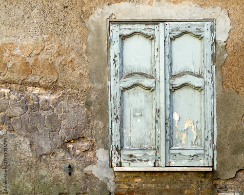 Old window shutters in a damaged concrete wall.