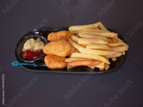Golden Fried Chicken Nuggets and French Fries Served