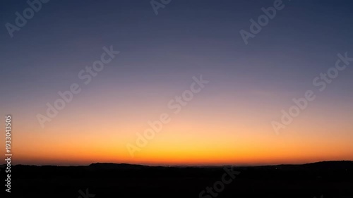 Time lapse sequence of a vibrant sunrise presented as a three panel triptych. Beautiful gradient sky from deep blue to warm orange over a dark horizon silhouette