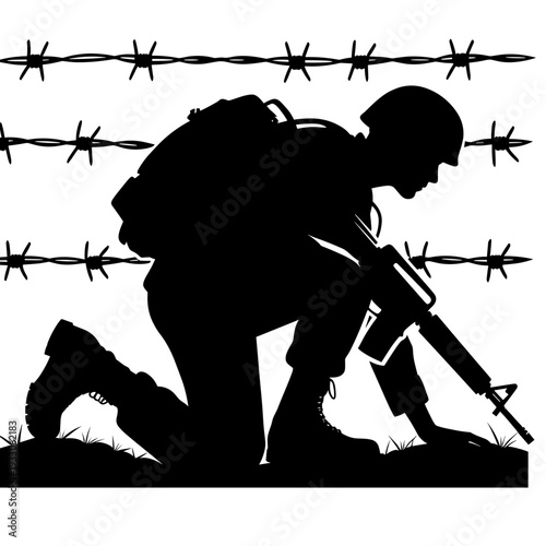 Soldier crouching with rifle behind barbed wire fence