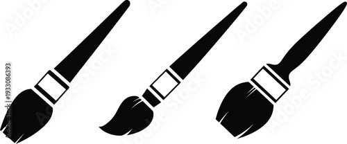 Three black paintbrushes with white ferrules on a white background