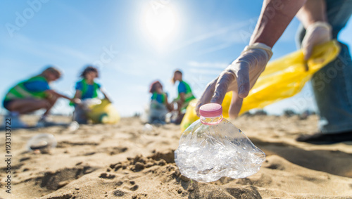 Group of eco volunteers picking up plastic trash on the beach - Activist people collecting garbage protecting the planet - Ocean pollution, environmental conservation and ecology concept