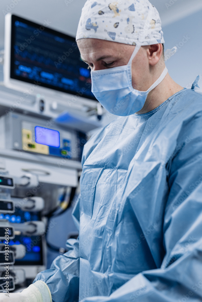 Naklejka premium Surgeon performing operation with medical monitors visible in background. Concept of medical technologies and surgery. 