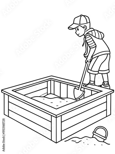 Young boy shoveling sand into a wooden sandbox with a bucket nearby waiting to be used