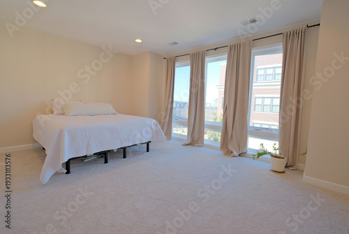 Empty home bedroom interior featuring floor to ceiling windows