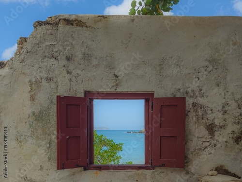 Cinnamon Bay Beach on Saint John USVI with an old window in the wall with a view of the ocean