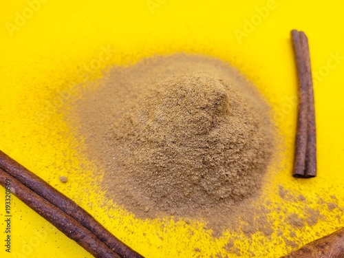 Aromatic portion of cinnamon against a yellow background