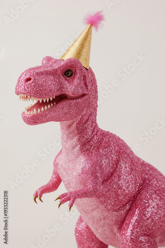 Dinosaur t-rex figurine, covered with pink glitters, wearing golden party hat