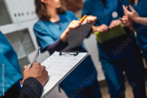 Veterinary staff collaborating on patient records clipboard