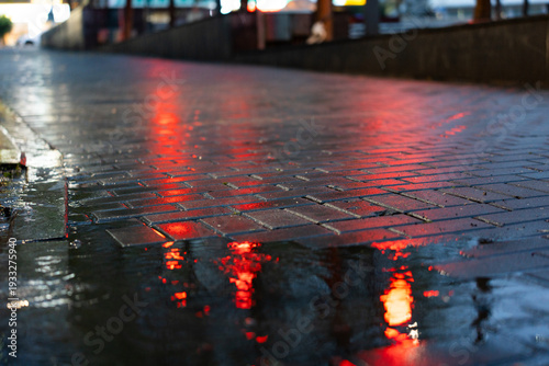 Wet city street at night with red light reflections on cobblestones in Shanghai, China