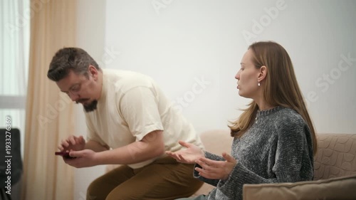 Angry husband grabbing wife's phone during argument