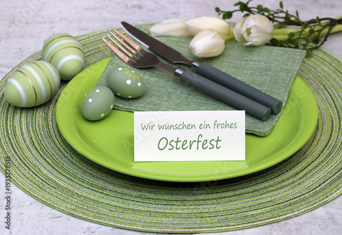 Karte mit dem Text wir wünschen ein frohes Osterfest auf einem Teller mit Osterdekoration.