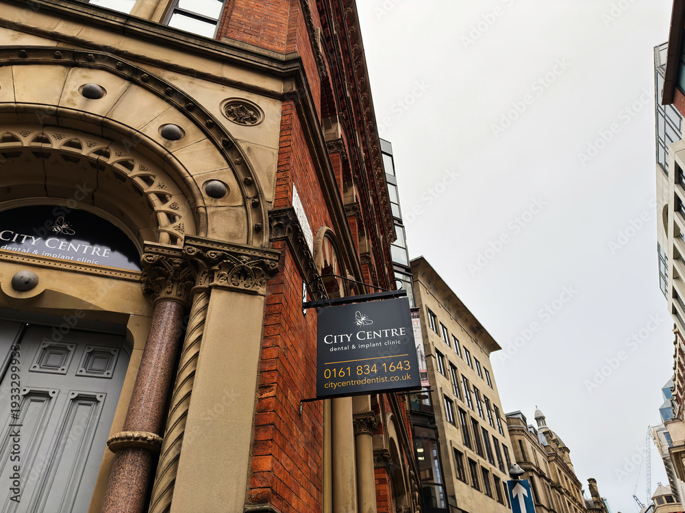 Fototapeta premium City Centre Manchester dental and implant clinic sign on historic brick building in urban street