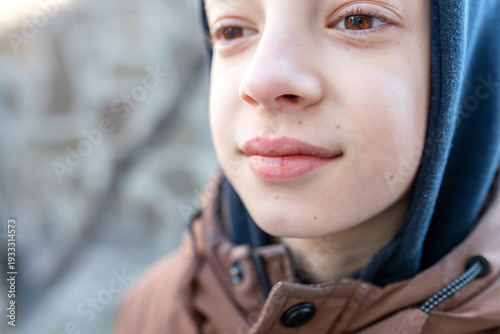 Fotografie Close up of a boy in a hooded jacket looking focused