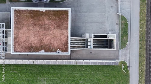 Close up drone shot of rotating Archimedes screw pump lifting water at a modern wastewater treatment facility. Industrial water management and environmental engineering concept.