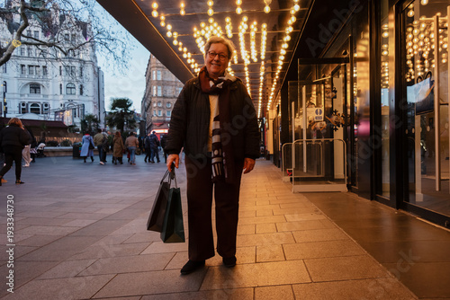 Senior woman enjoying shopping trip in London city lights