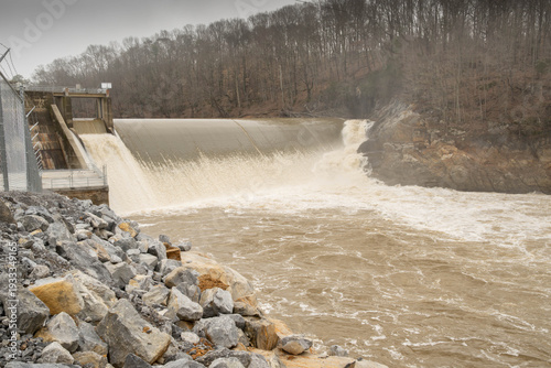 Canvas-taulu Mist sprays into air above the raging muddy river water flowing over the Nolichucky Dam