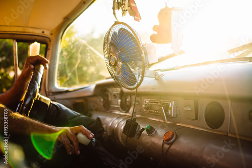 Driving in sunlight with an old vehicle and a hand on the gear shift