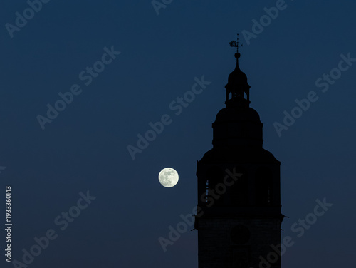 moon next to a church tower at sunset