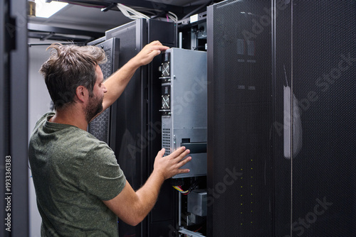 Photos IT technician installing server hardware in a data center rack performing mainte