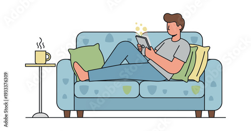 Man lounging casually on a sofa, reading an e-book or browsing content on a digital tablet with a hot cup of coffee nearby