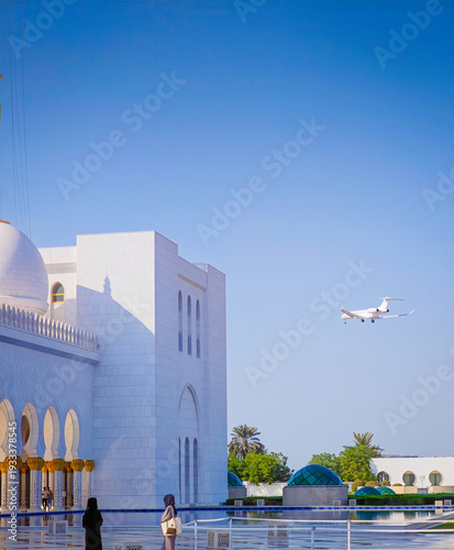 Private jet landing at Al Bateen Executive Airport in front of Sheikh Zayed Grand Mosque in Abu Dhabi