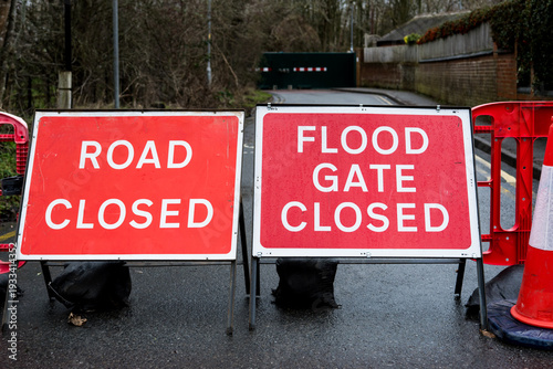 Red flood barrier warning signs on a road