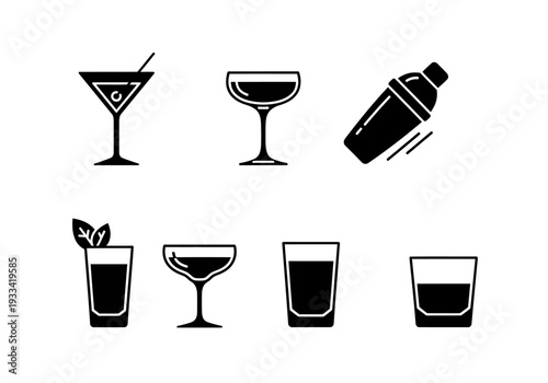 Assorted cocktail glasses and a shaker displayed together on a clean, simple background from a straightforward viewpoint.