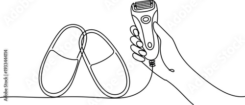 A hand holding an electric shaver next to a pair of slippers on a white background