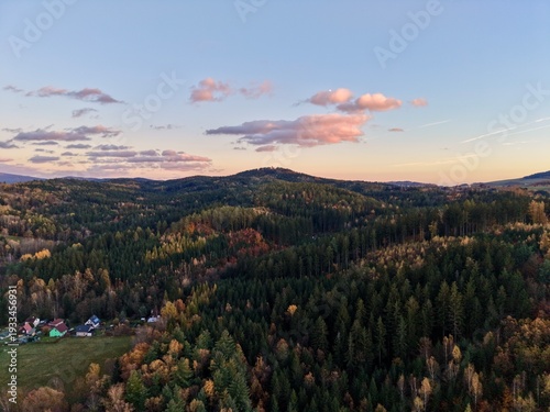 pink sunset landscape, warm pastel glow casts serene ambiance across forested hills and distant slopes