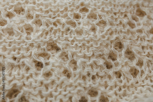 Natural wool knitted openwork pattern with soft loops and cozy handmade texture