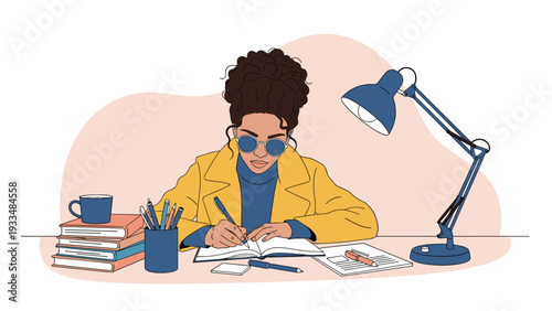 Focused young woman wearing glasses and a yellow coat writes diligently in a notebook at her desk under a bright lamp.