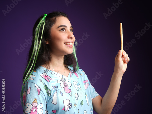Fotografi A smiling woman dentist holding an ancestral toothbrush Miswak