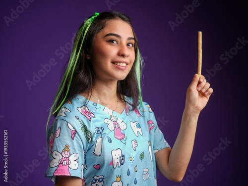A woman dentist holding an ancestral toothbrush Miswak