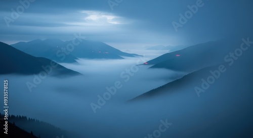 Dramatic misty mountain range landscape with low clouds and atmospheric lighting