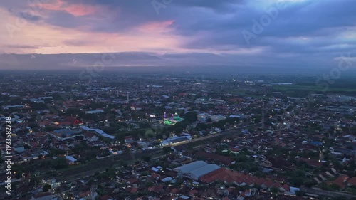 Wallpaper Mural Aerial perspective over the city of probolinggo in east java, indonesia. The cityscape lights are turning on under a cloudy sunset sky Torontodigital.ca
